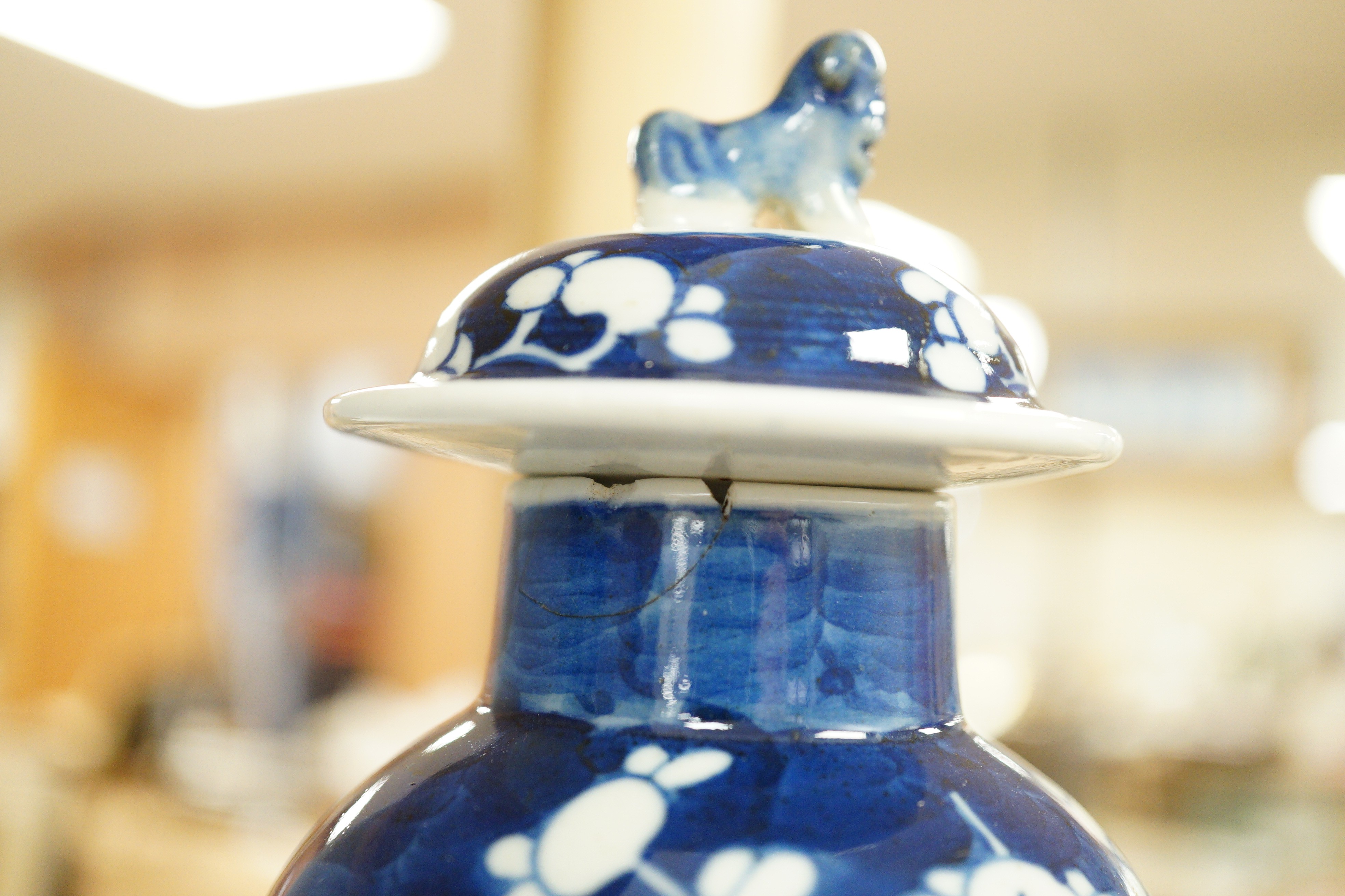 A pair of early 20th century Chinese blue and white ‘prunus’ vases and covers, 21cm